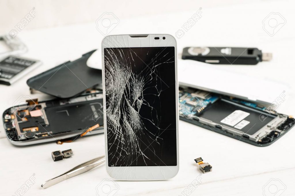 Cell phone with broken display among disassembled gadgets